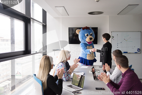 Image of boss dresed as bear having fun with business people in trendy of