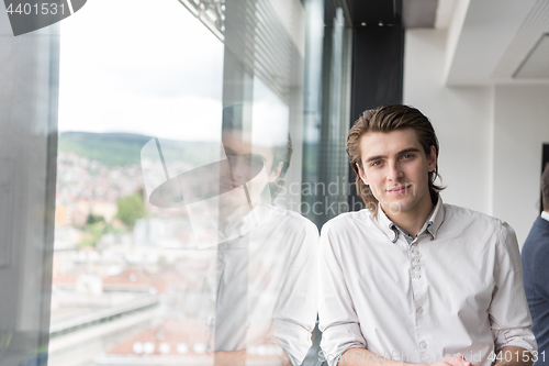 Image of young businessman in startup office by the window
