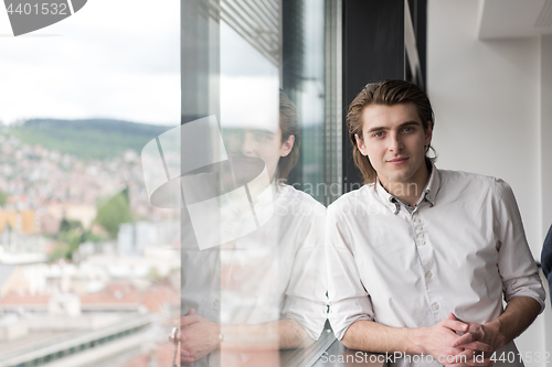 Image of young businessman in startup office by the window