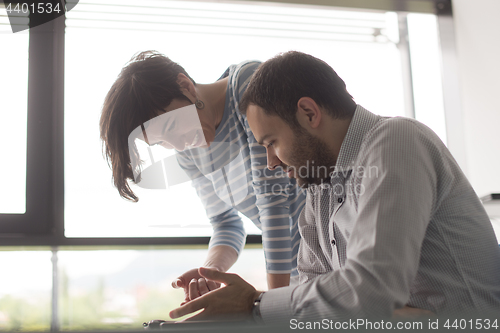 Image of Two Business People Working With Tablet in startup office