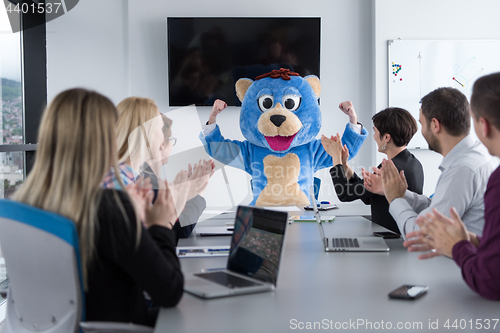 Image of boss dresed as bear having fun with business people in trendy of