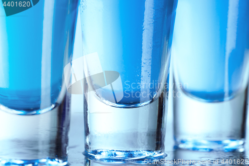 Image of Vodka glass with ice on blue background