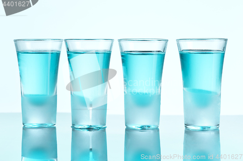 Image of Vodka glass with ice on blue background