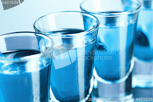 Image of Vodka glass with ice on blue background