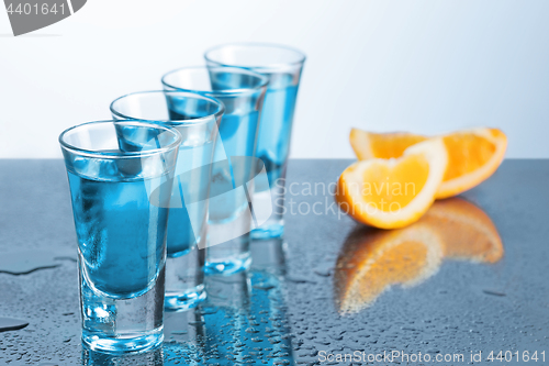 Image of Vodka glass with ice on blue background