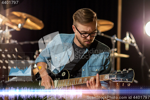 Image of guitarist playing guitar at sound recording studio