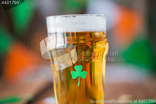 Image of close up of glass of draft beer with shamrock