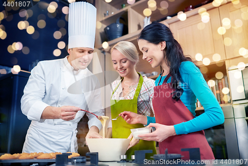 Image of happy women and chef cook baking in kitchen