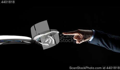 Image of robot and human hand connecting fingers