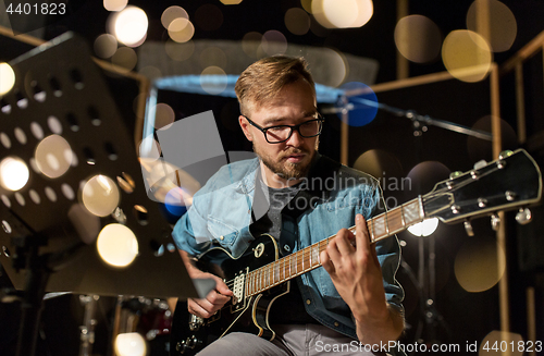 Image of man playing guitar at studio rehearsal