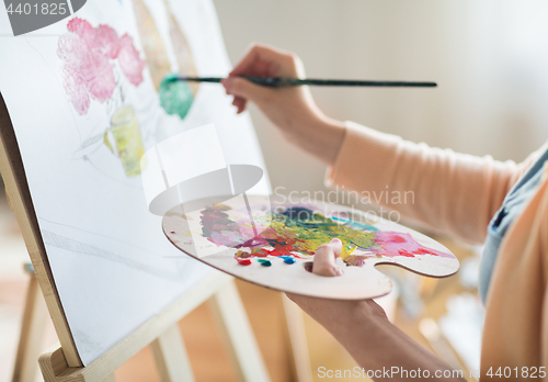 Image of artist with palette painting at art studio