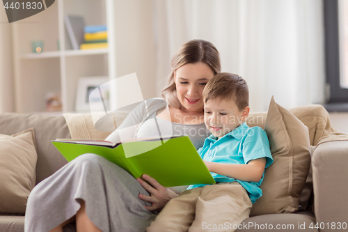 Image of happy family reading book at home