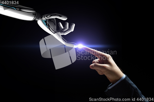 Image of robot and human hand connecting fingers