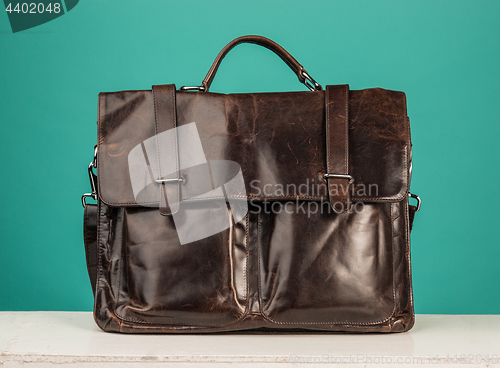 Image of A vintage leather briefcase on a blue background