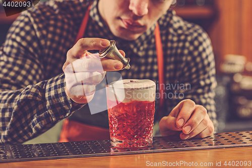 Image of Barman making an alcoholic cocktail at the bar counter on the bar background