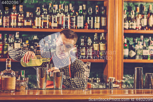 Image of Barman making an alcoholic cocktail at the bar counter on the bar background