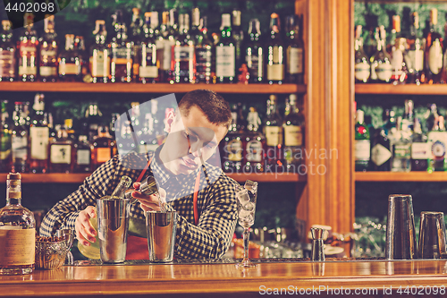 Image of Barman making an alcoholic cocktail at the bar counter on the bar background