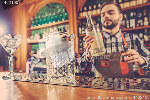 Image of Barman making an alcoholic cocktail at the bar counter on the bar background