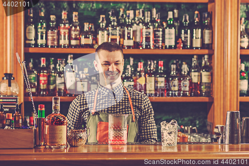 Image of Barman offering an alcoholic cocktail at the bar counter on the bar background