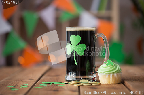 Image of shamrock on glass of beer, green cupcake and coins