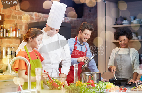 Image of happy friends and chef cook cooking in kitchen