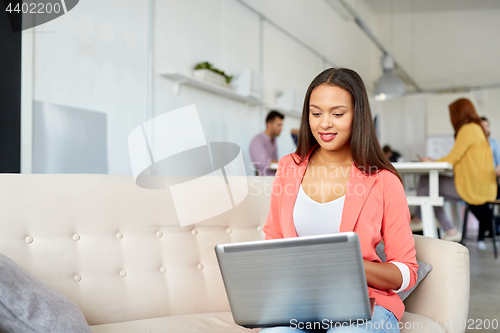 Image of happy woman with laptop working at office