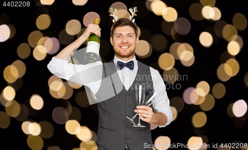 Image of man with bottle of champagne at christmas party