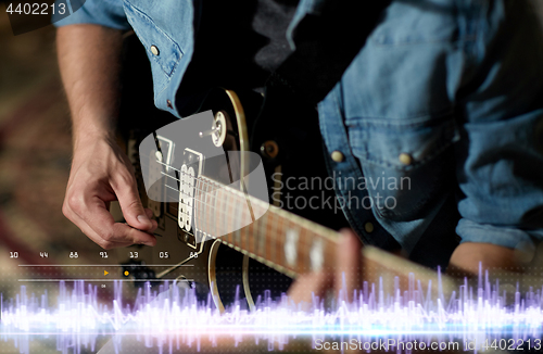 Image of close up of man playing guitar at studio rehearsal