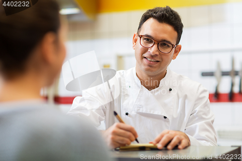 Image of chef at fast food restaurant writing order