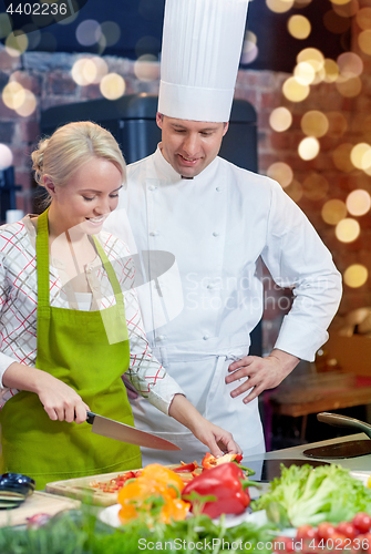 Image of happy male chef cook with woman cooking in kitchen