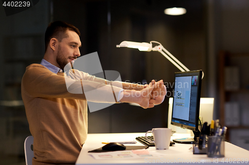 Image of man with computer working late at night office