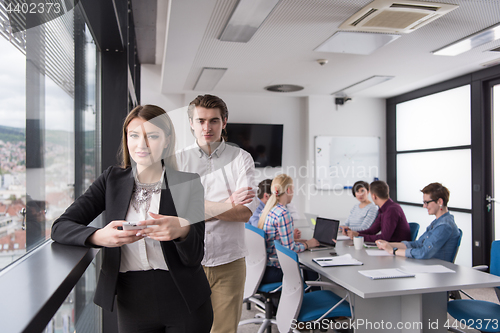 Image of Elegant Woman Using Mobile Phone by window in office building