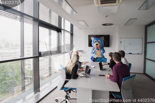 Image of boss dresed as bear having fun with business people in trendy of