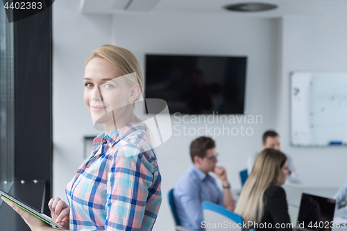 Image of Pretty Businesswoman Using Tablet In Office Building by window