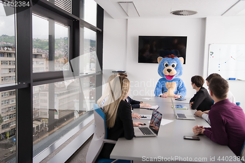 Image of boss dresed as bear having fun with business people in trendy of