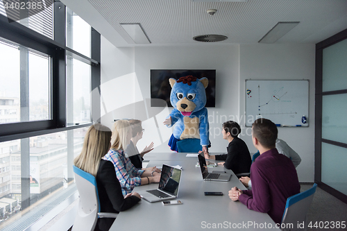 Image of boss dresed as bear having fun with business people in trendy of