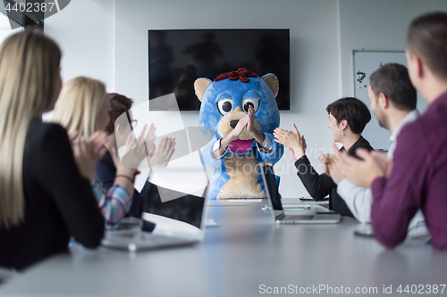 Image of boss dresed as bear having fun with business people in trendy of