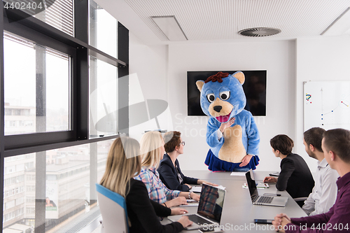 Image of boss dresed as bear having fun with business people in trendy of