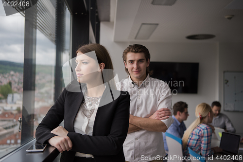 Image of Elegant Woman Using Mobile Phone by window in office building