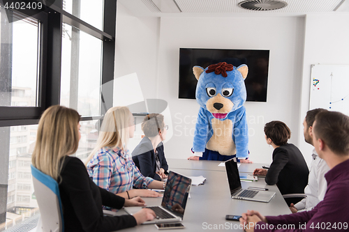 Image of boss dresed as bear having fun with business people in trendy of