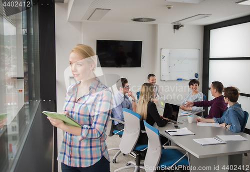 Image of Pretty Businesswoman Using Tablet In Office Building by window