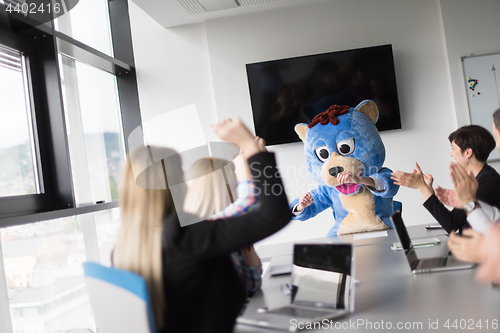 Image of boss dresed as bear having fun with business people in trendy of