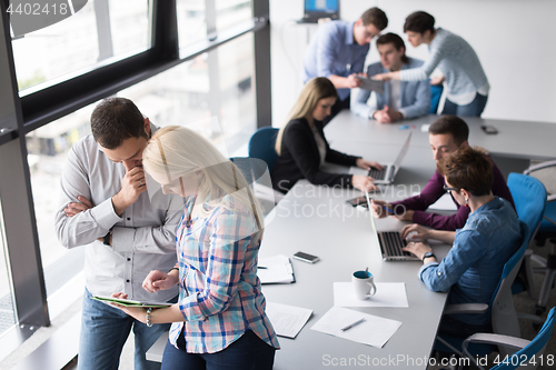 Image of Two Business People Working With Tablet in office