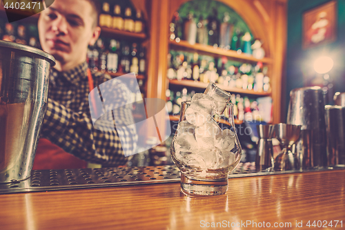 Image of Barman making an alcoholic cocktail at the bar counter on the bar background