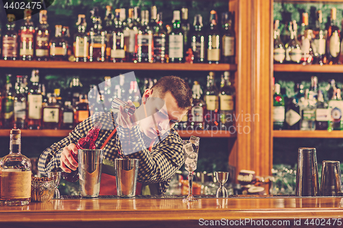 Image of Barman making an alcoholic cocktail at the bar counter on the bar background