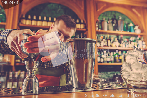 Image of Barman making an alcoholic cocktail at the bar counter on the bar background