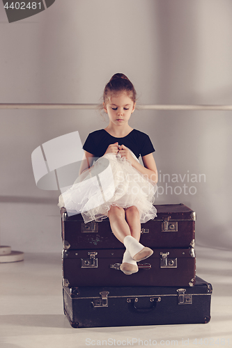 Image of The little girl as balerina dancer sitting at studio