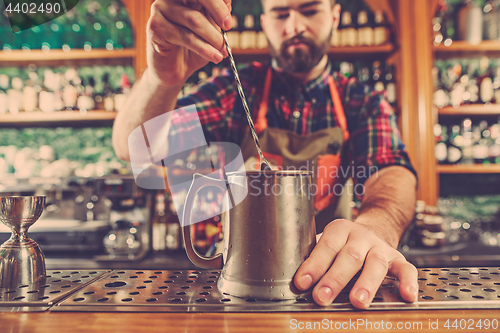 Image of Barman making an alcoholic cocktail at the bar counter on the bar background