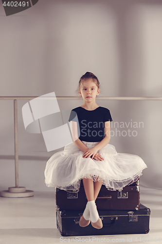 Image of The little girl as balerina dancer sitting at studio