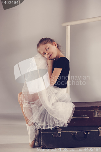 Image of The little girl as balerina dancer sitting at studio